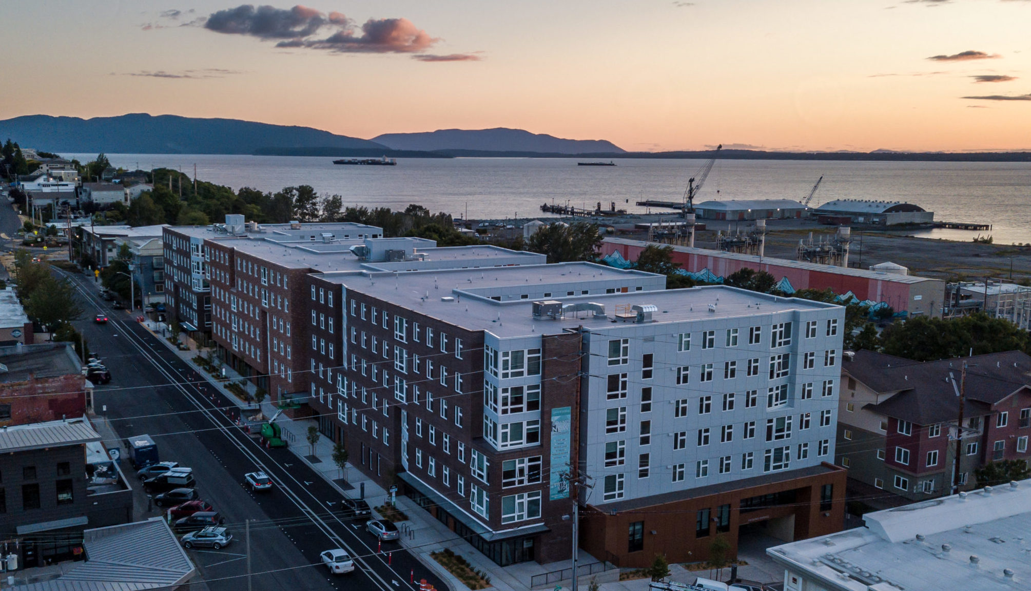 Building exterior with water and sunset in the background