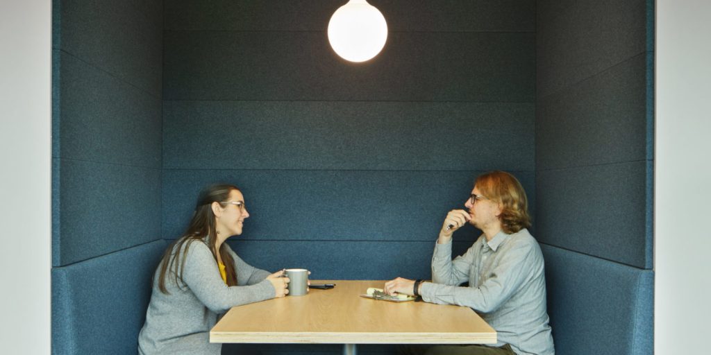 Two people talking in a private booth