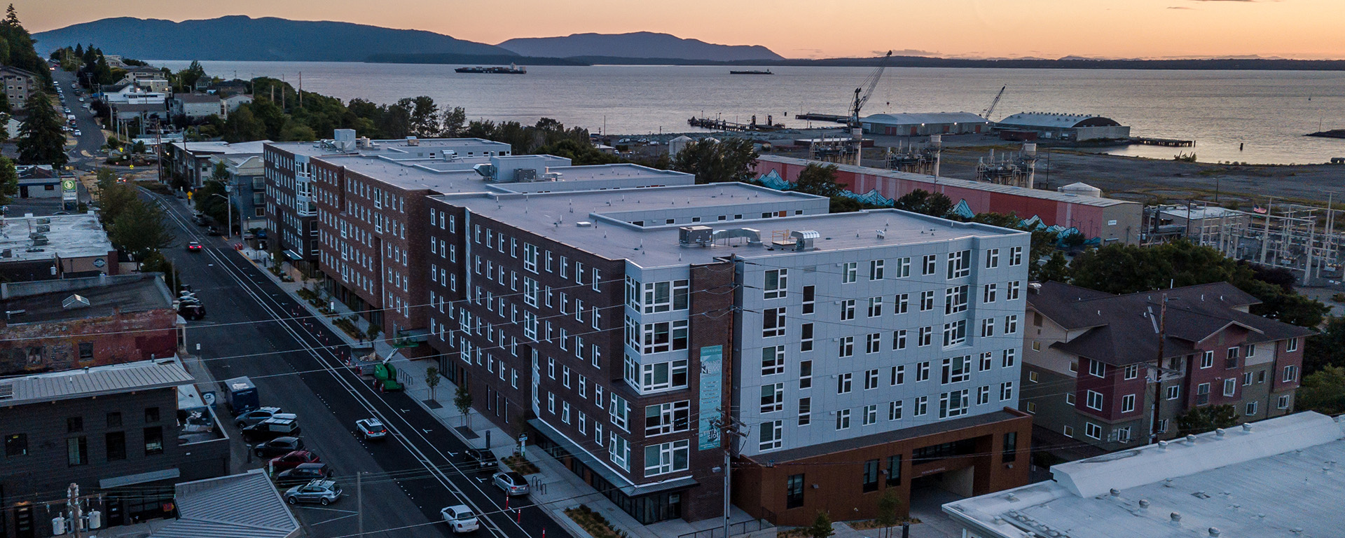 Building exterior with water and sunset in the background